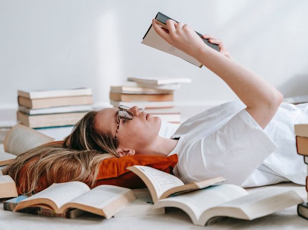 Frau liegt in Büchern und liest